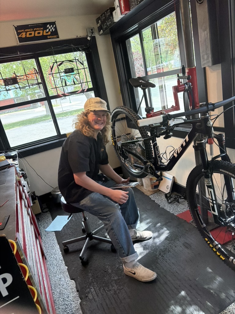 Friendly Power House bicycle technician beside a mountain bike